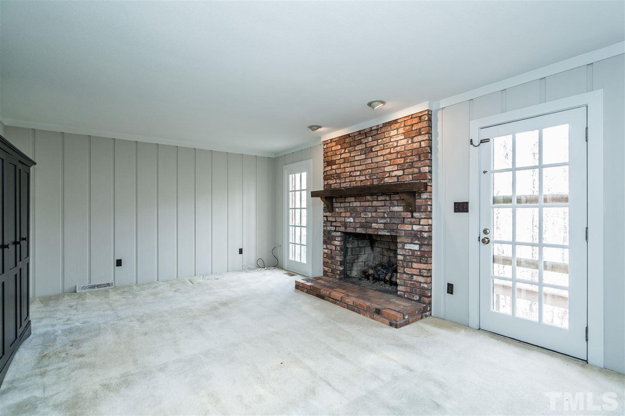 4516 Connell Drive Raleigh, NC 27612 - Photo 7 of 28 an empty room with windows and fireplace