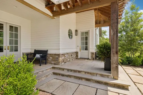 a view of a patio with table and chairs and potted plants