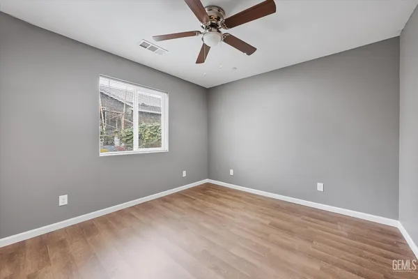 an empty room with a window and a fan