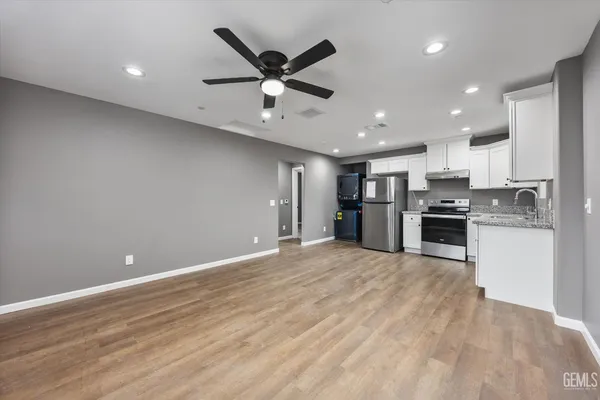 an open kitchen with kitchen island white cabinets and stainless steel appliances