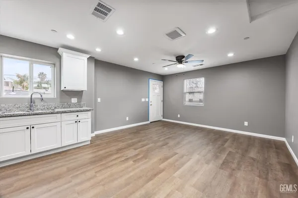 a view of an empty room with window and wooden floor