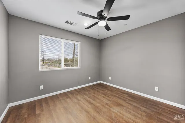 an empty room with a window and a fan