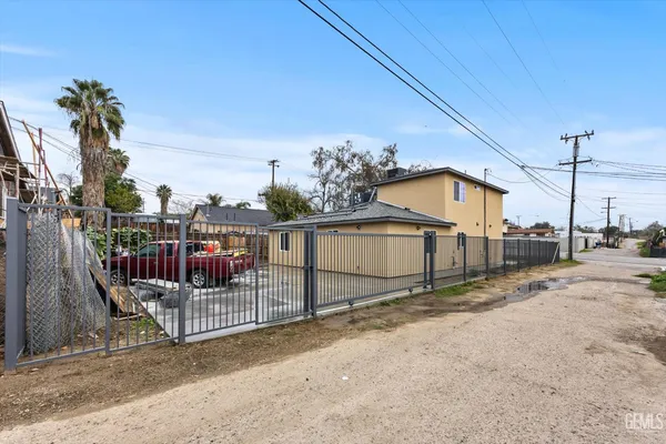 a view of a house with a small yard and wooden fence