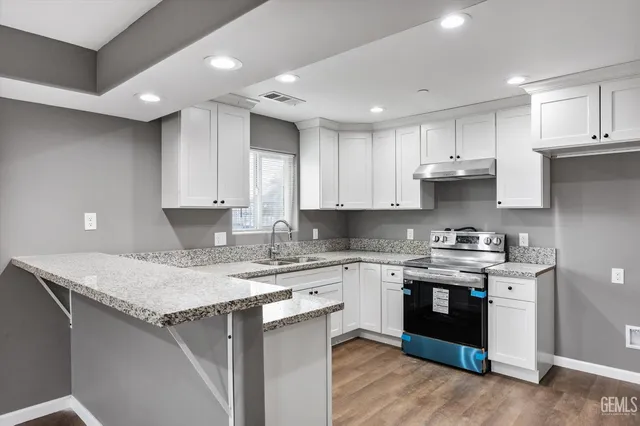 a kitchen with a sink a stove a cabinets and a counter top space