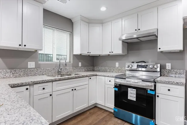 a kitchen with granite countertop cabinets stainless steel appliances and a sink