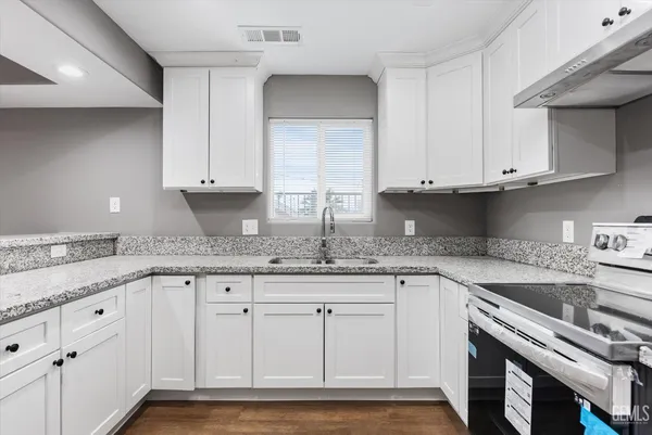 a kitchen with granite countertop cabinets and white appliances