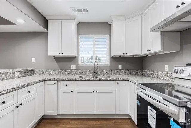 a kitchen with granite countertop cabinets and white appliances