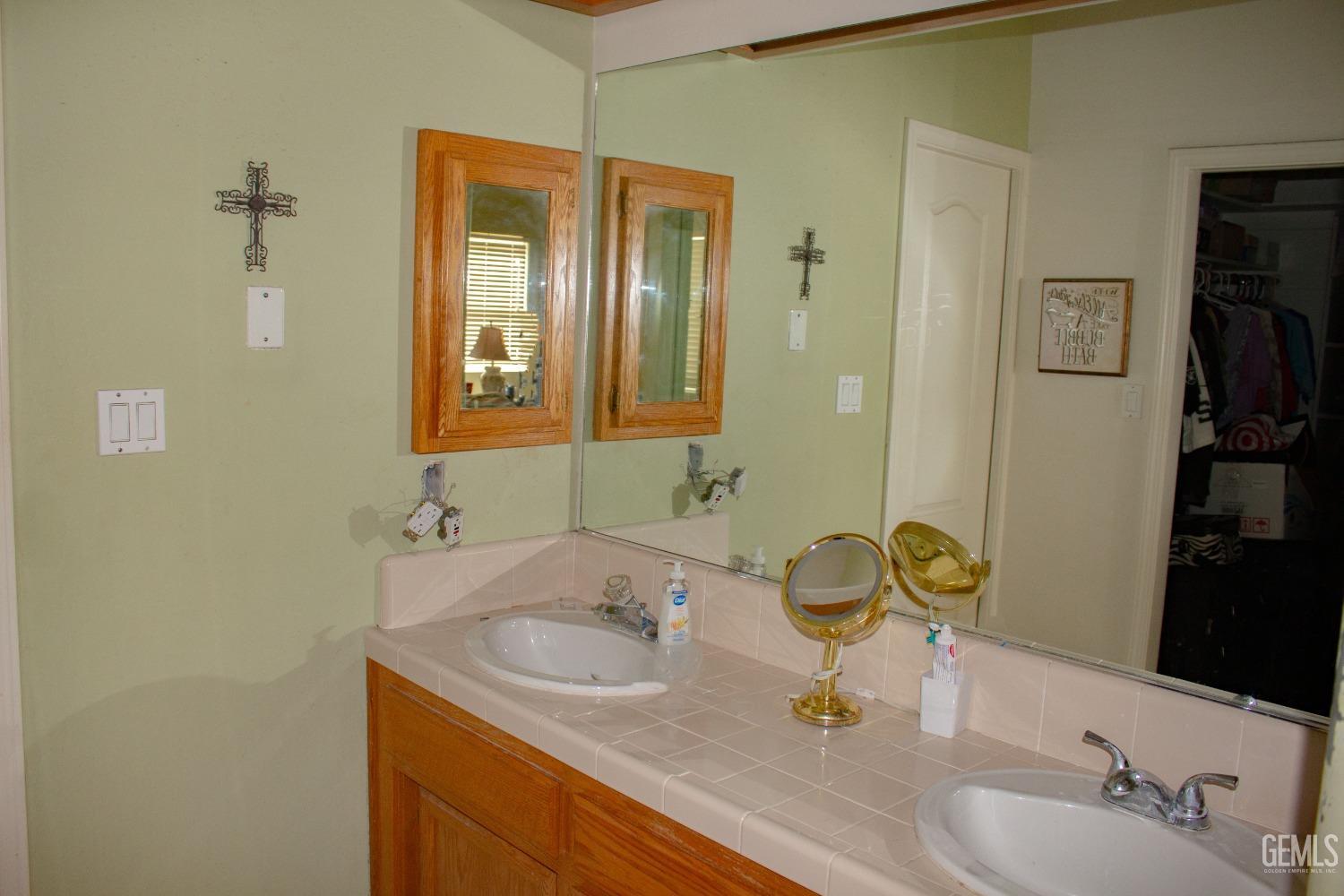 Undisclosed Address Bakersfield, CA 93313 - Photo 13 of 17 a bathroom with a granite countertop sink and a mirror