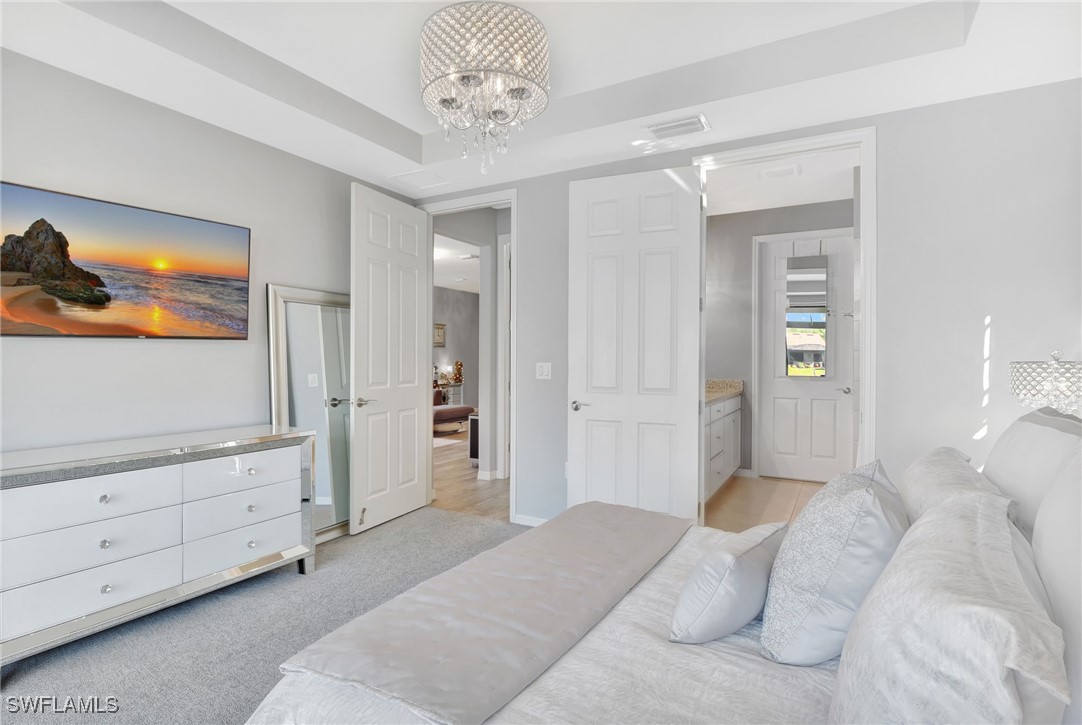 10908 Clarendon Street Fort Myers, FL 33913 - Photo 18 of 49 a spacious bedroom with a bed and a chandelier