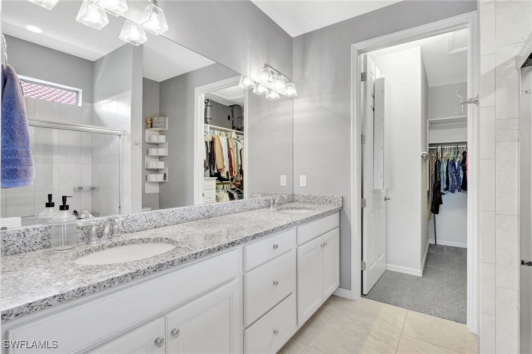 10908 Clarendon Street Fort Myers, FL 33913 - Photo 20 of 49 a bathroom with a granite countertop double vanity sink a mirror and a shower