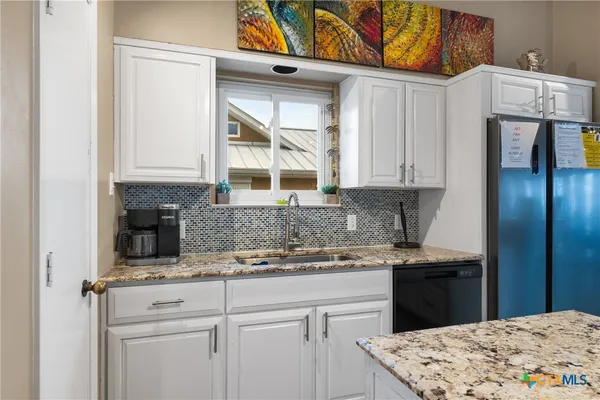 a kitchen with stainless steel appliances granite countertop a sink and cabinets