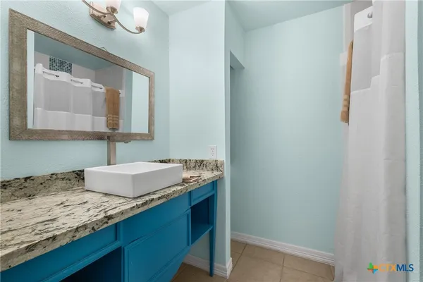 a bathroom with a granite countertop sink and a mirror