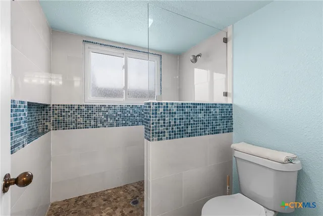 a bathroom with a sink a toilet and a shower