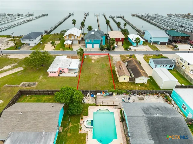 an aerial view of residential houses with outdoor space and swimming pool