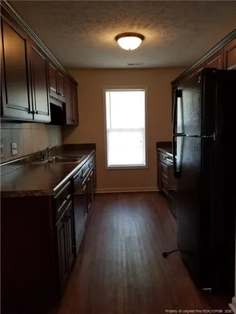 a kitchen that has a sink wooden cabinets and stainless steel appliances