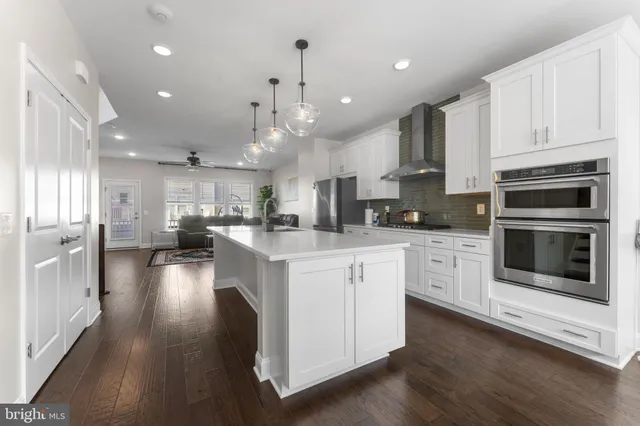 a large kitchen with stainless steel appliances kitchen island granite countertop a large cabinets a sink and a stove