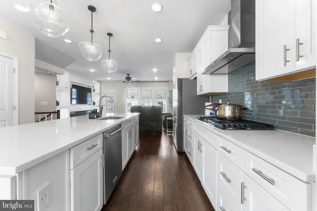 a large kitchen with stainless steel appliances lots of counter space a sink and a stove