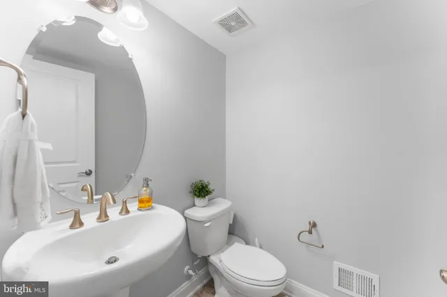 a bathroom with a sink a toilet and a mirror