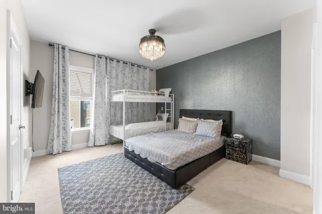 a bedroom with a large bed and a chandelier