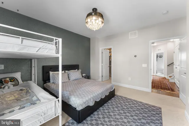 a bedroom with a large bed and a chandelier