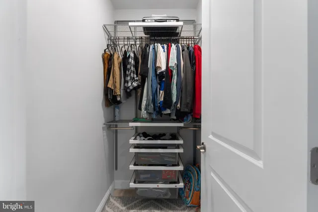 a view of walk in closet with clothes and shoes