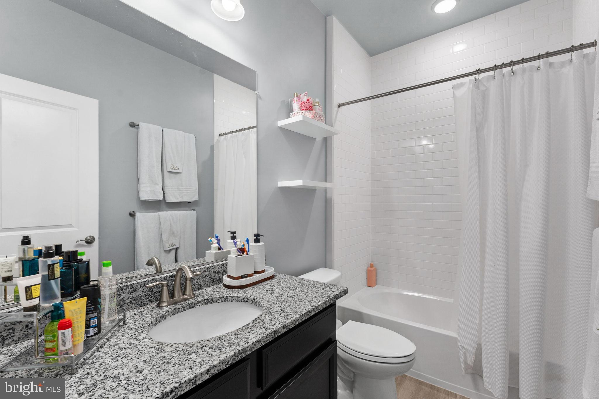 17372 Redshank Road Dumfries, VA 22026 - Photo 32 of 51 a bathroom with a granite countertop sink a toilet and shower