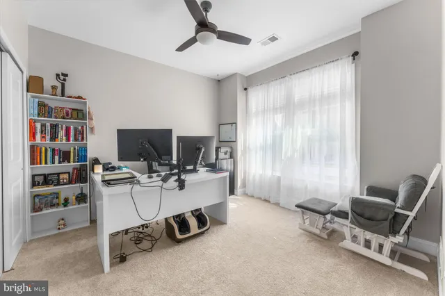 a view of a workspace with furniture and a window