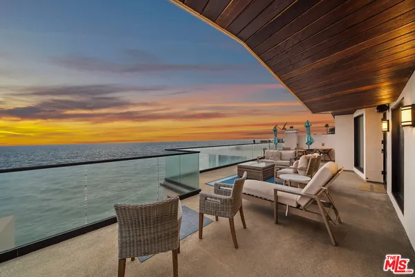 a roof deck with outdoor seating and city view