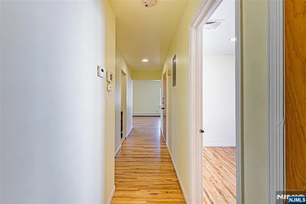 a view of a hallway with wooden floor