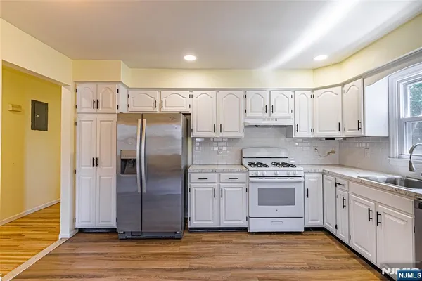 a kitchen with stainless steel appliances a refrigerator sink and cabinets