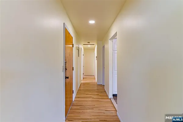 a view of a hallway with wooden floor and staircase