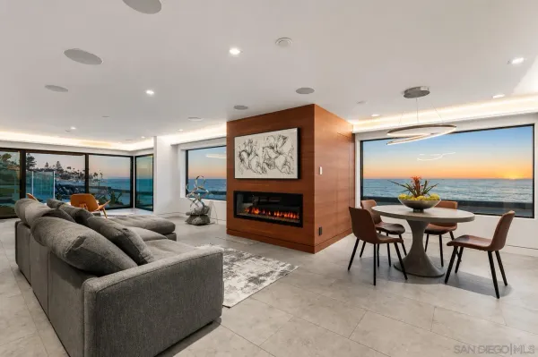 a living room with furniture a fireplace and a large window