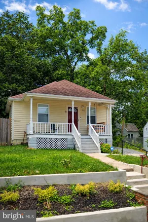 a front view of a house with a yard and green space