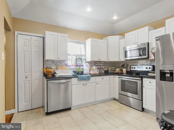 a kitchen with stainless steel appliances granite countertop a refrigerator sink and cabinets
