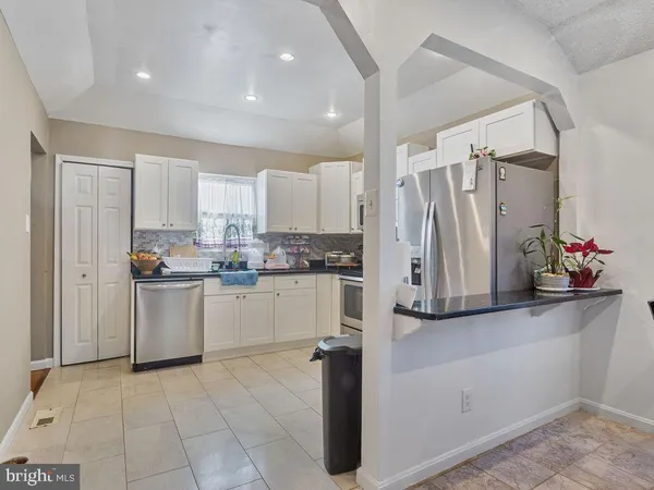 a kitchen with a refrigerator and white cabinets