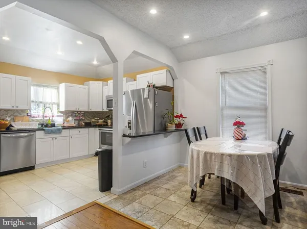 a kitchen with stainless steel appliances kitchen island granite countertop a refrigerator and microwave