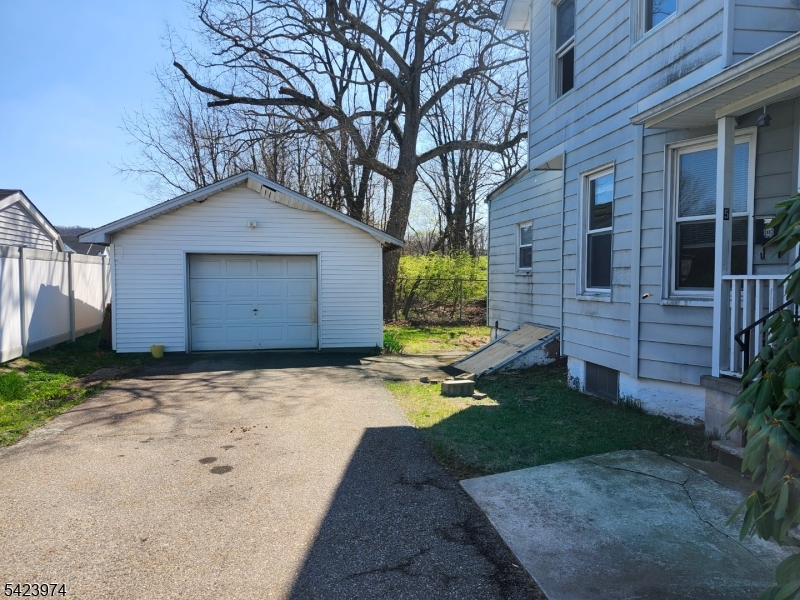 5 Locust Street Wanaque, NJ 07420 - Photo 7 of 23 a front view of a house with a yard and garage