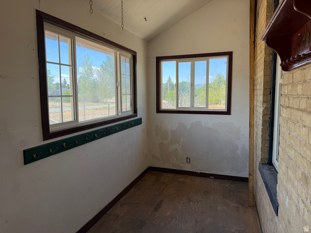 255 E Centre Spring City, UT 84662 - Photo 5 of 31 Enclosed porch featuring multiple windows, sloped ceiling, wood-finish baseboards, and a brick exterior wall