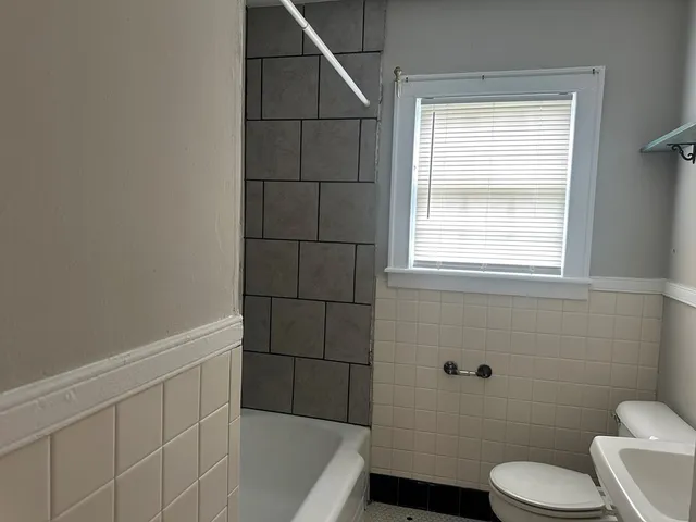 a bathroom with a toilet a sink a bath tub and a window