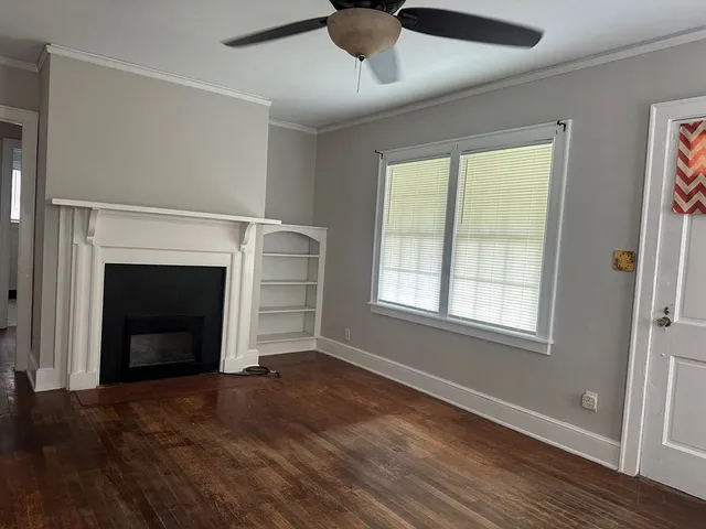 a view of an empty room with a fireplace and a window