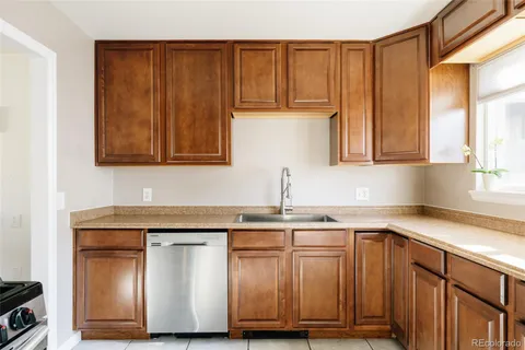 a kitchen with stainless steel appliances granite countertop wooden cabinets and a sink