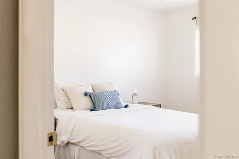 a bedroom with a white bed and a white cabinet