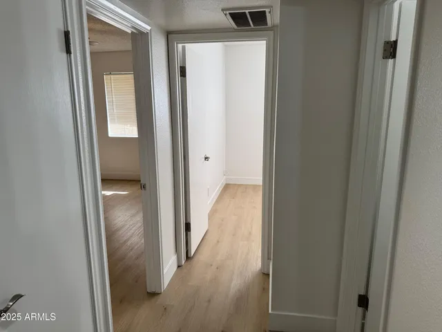 a view of a hallway with wooden floor