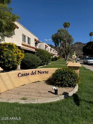 a view of a house with a yard and potted plants