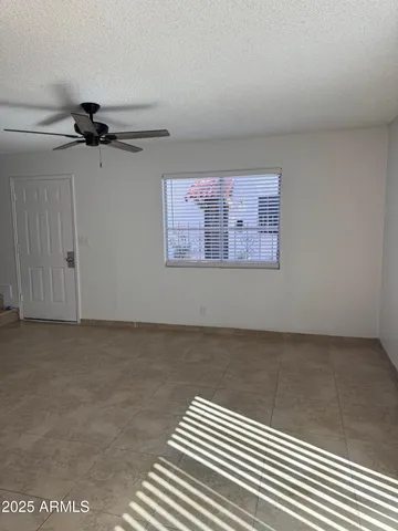 a view of a room with a ceiling fan and window