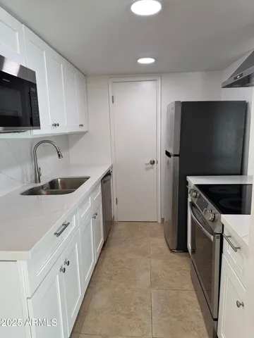 a kitchen with stainless steel appliances granite countertop a sink stove and refrigerator