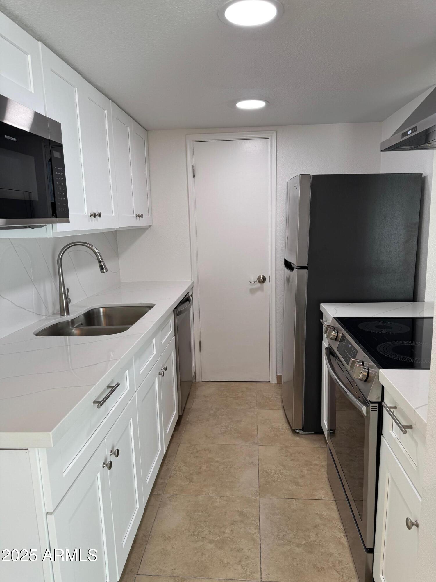 8861 North 12th Place Phoenix, AZ 85020 - Photo 8 of 25 a kitchen with stainless steel appliances granite countertop a sink stove and refrigerator
