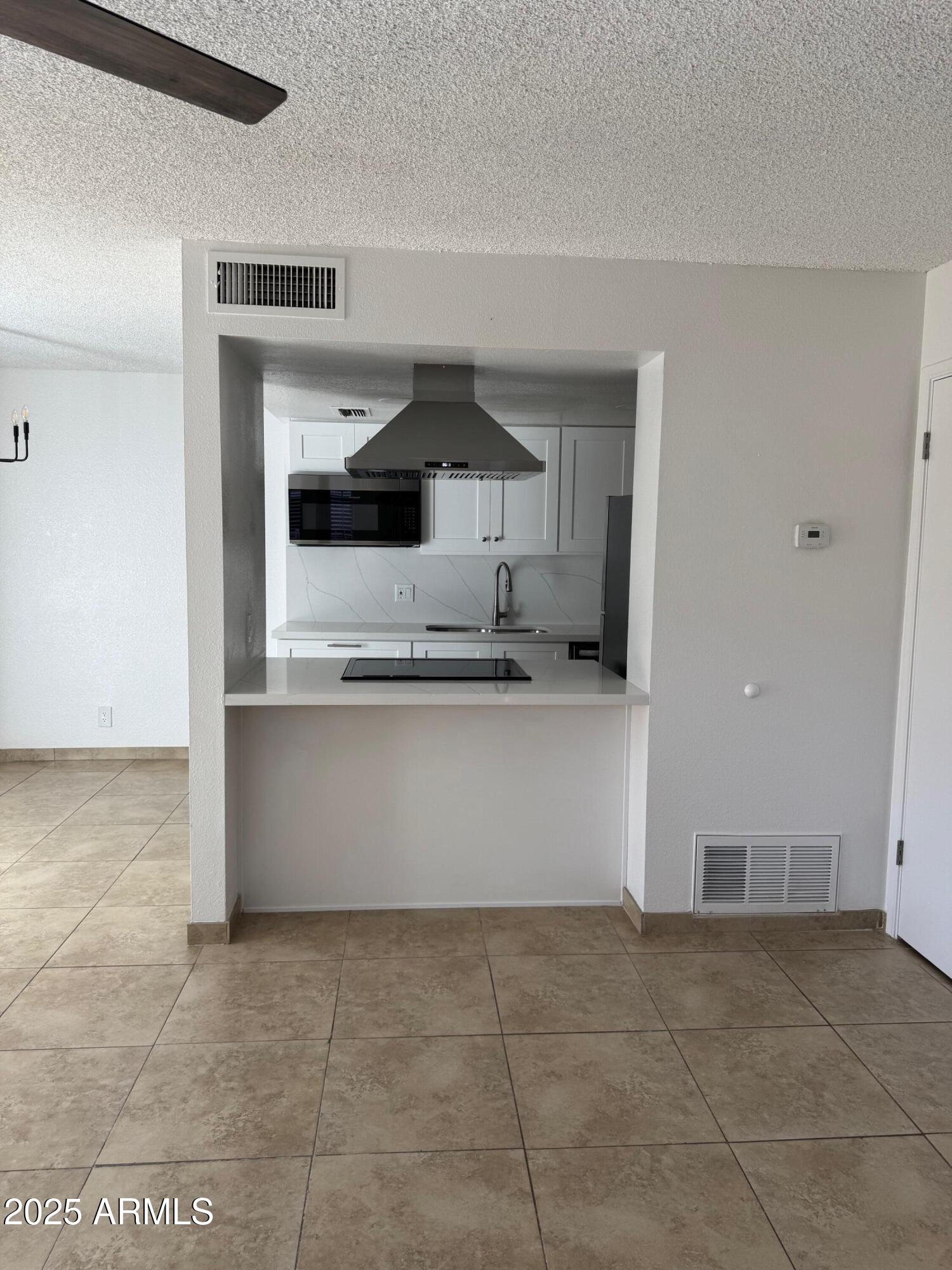 8861 North 12th Place Phoenix, AZ 85020 - Photo 9 of 25 a kitchen with kitchen island a sink a stove and cabinets