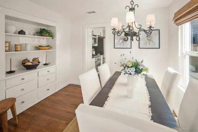 a kitchen with stainless steel appliances granite countertop a stove a sink dishwasher and a dining table with cabinets