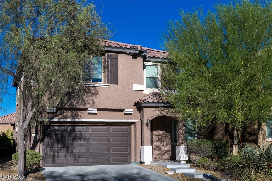 11016 Prairie Grove Road Las Vegas, NV 89179 - Photo 2 of 37 A terracotta-tiled roof crowns this appealing stucco home, featuring an arched entry and a two-car garage.